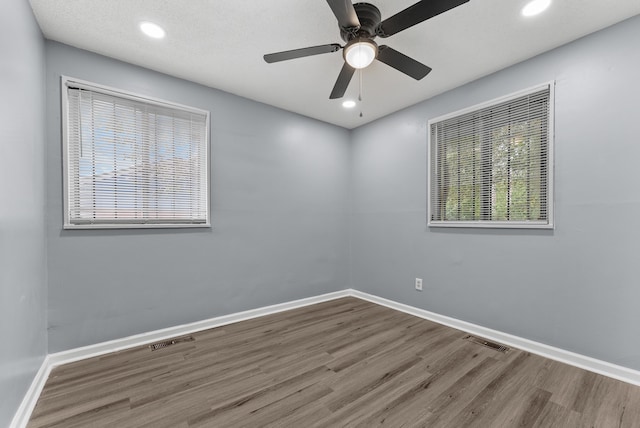 unfurnished room with hardwood / wood-style floors, ceiling fan, and a textured ceiling