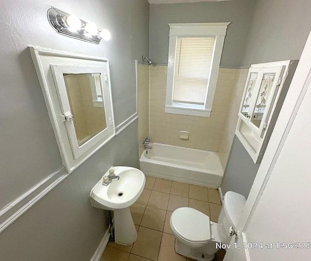 bathroom with shower / bathing tub combination, tile patterned flooring, and toilet