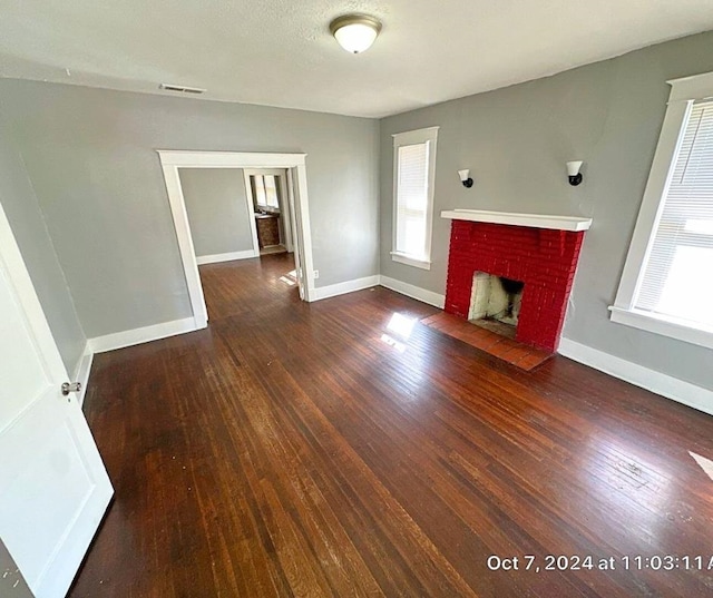 unfurnished living room with dark hardwood / wood-style flooring and a fireplace