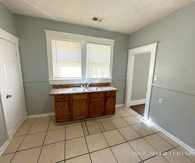 bathroom featuring tile patterned floors, sink, and a textured ceiling