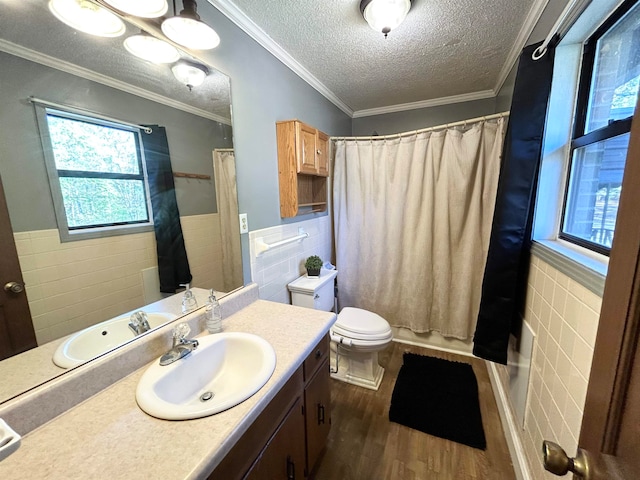 full bathroom with a wealth of natural light, tile walls, wood-type flooring, and vanity