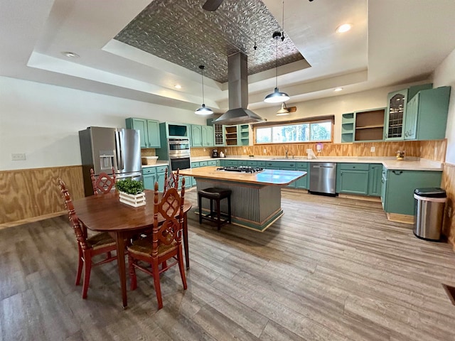 dining space with hardwood / wood-style floors, a tray ceiling, and sink