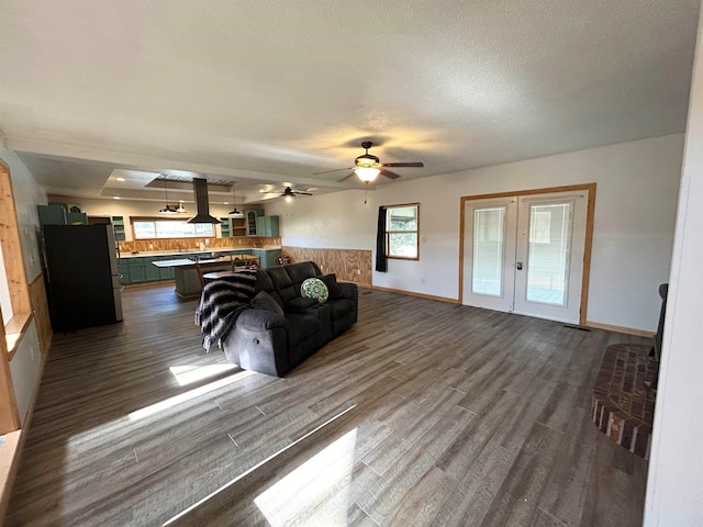 living room with ceiling fan, dark wood-type flooring, a textured ceiling, and french doors