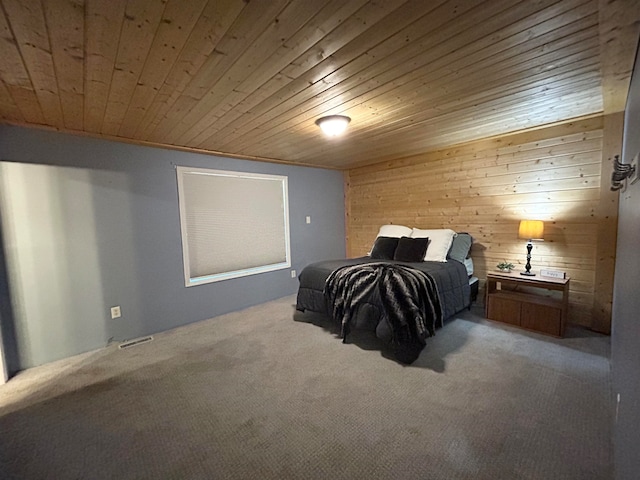 carpeted bedroom featuring ornamental molding, wood walls, and wood ceiling