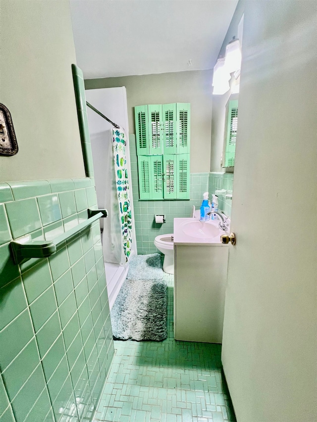 bathroom featuring tile walls, curtained shower, vanity, and toilet