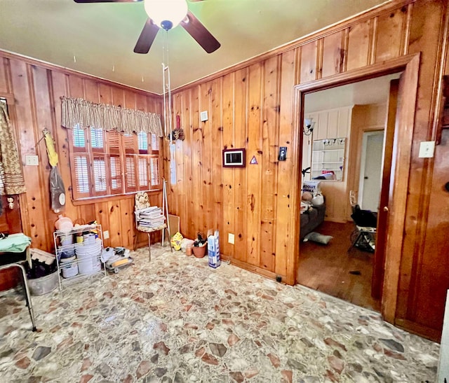 misc room featuring wood walls, hardwood / wood-style flooring, and ceiling fan