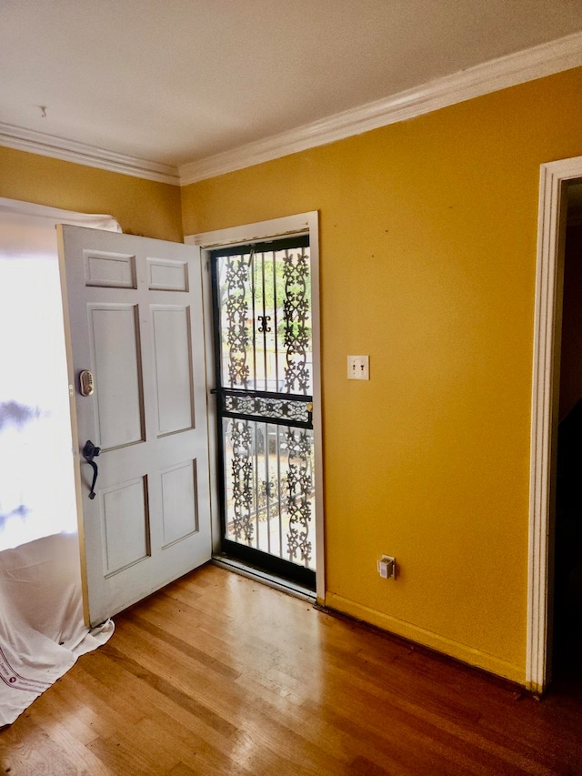 entryway with hardwood / wood-style floors and ornamental molding