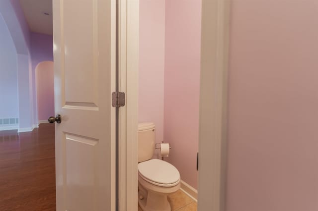 bathroom featuring wood-type flooring and toilet