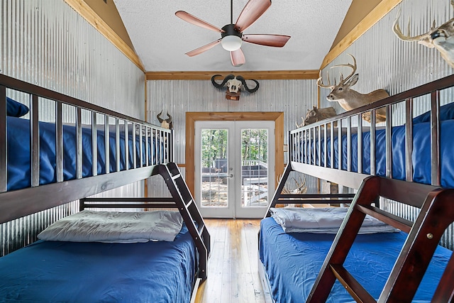 bedroom with french doors, lofted ceiling, a textured ceiling, hardwood / wood-style flooring, and ceiling fan