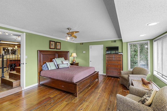 bedroom featuring ceiling fan, dark hardwood / wood-style floors, a textured ceiling, and ornamental molding