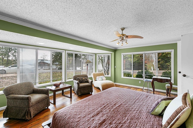 bedroom with hardwood / wood-style floors, ceiling fan, a textured ceiling, and ornamental molding