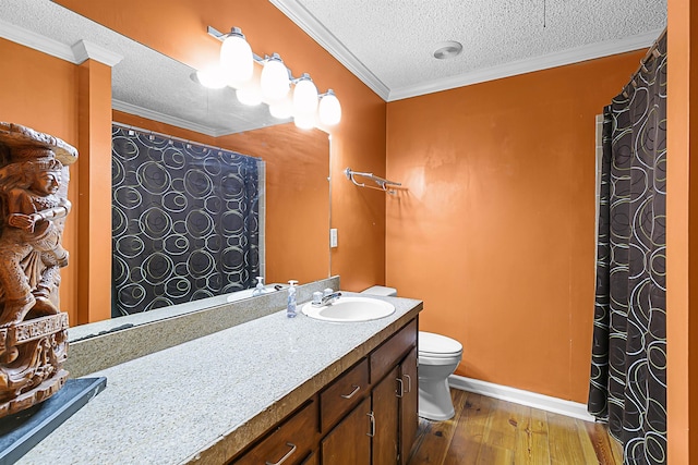 bathroom featuring wood-type flooring, ornamental molding, vanity, a textured ceiling, and toilet