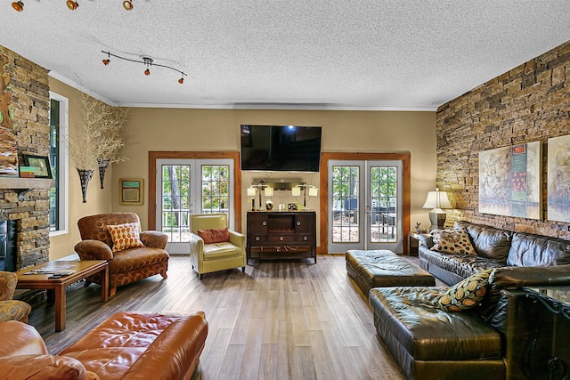 living room with french doors, hardwood / wood-style floors, ornamental molding, and a textured ceiling