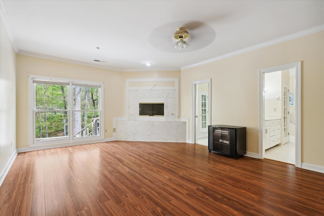 unfurnished living room with ornamental molding, hardwood / wood-style flooring, ceiling fan, and a high end fireplace