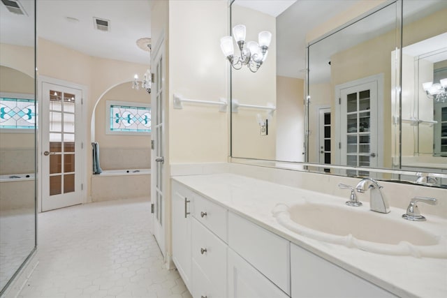 bathroom featuring tiled bath, tile patterned flooring, and vanity