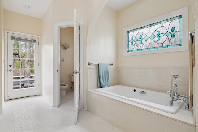 bathroom with a bath, tile patterned floors, toilet, and vaulted ceiling