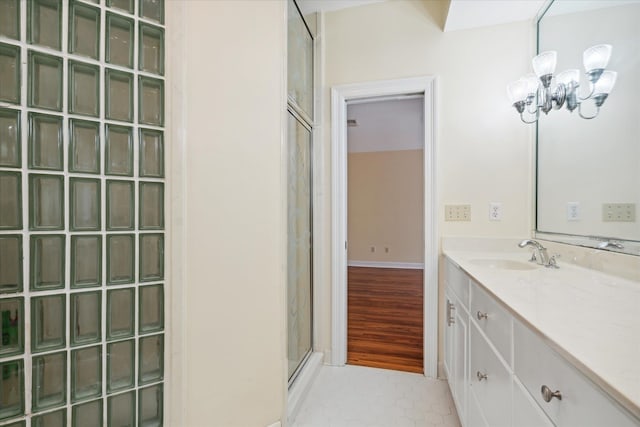 bathroom with a chandelier, vanity, tile patterned flooring, and a shower with shower door