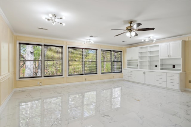 unfurnished living room with built in shelves, ceiling fan, and ornamental molding