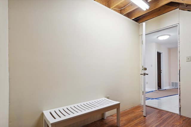 corridor featuring beamed ceiling and hardwood / wood-style flooring