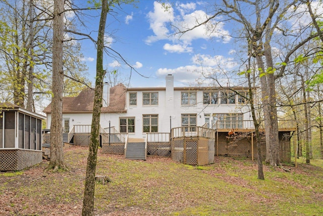 rear view of house with a sunroom and a wooden deck