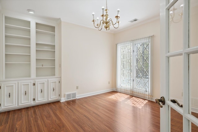 unfurnished room featuring hardwood / wood-style floors, an inviting chandelier, french doors, and ornamental molding