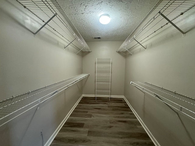 spacious closet featuring dark wood-type flooring