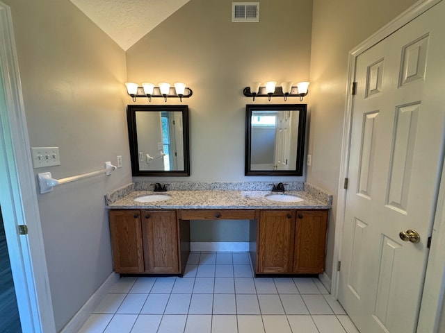 bathroom featuring tile patterned flooring, vanity, and lofted ceiling