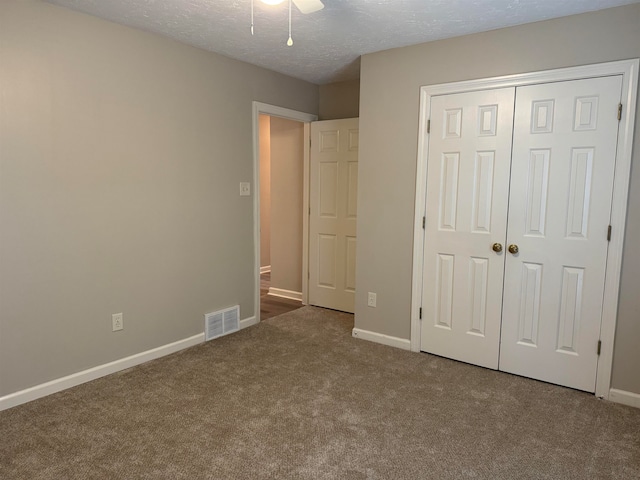 unfurnished bedroom featuring a closet, carpet floors, and a textured ceiling