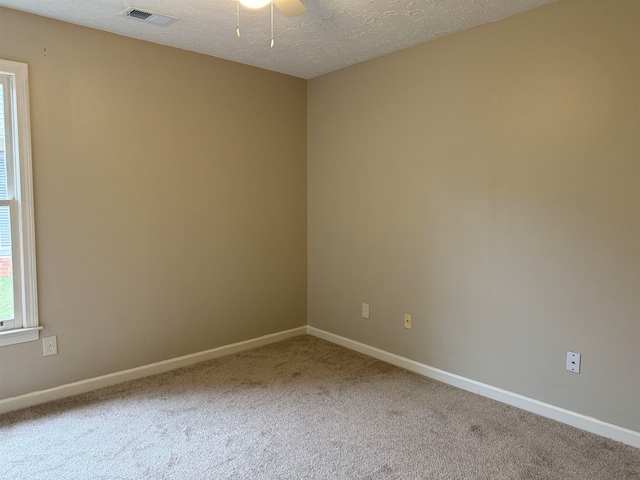 carpeted empty room with a textured ceiling