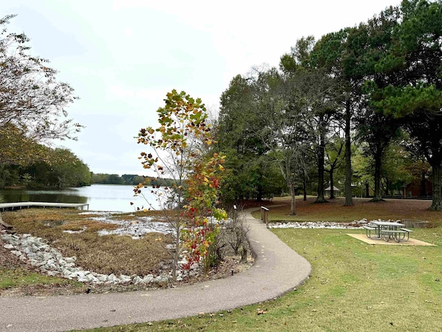 view of home's community featuring a lawn and a water view