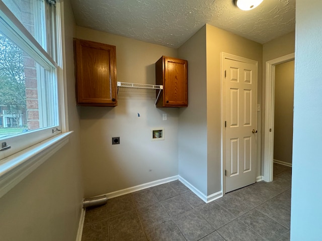 washroom with cabinets, washer hookup, light tile patterned floors, a textured ceiling, and hookup for an electric dryer