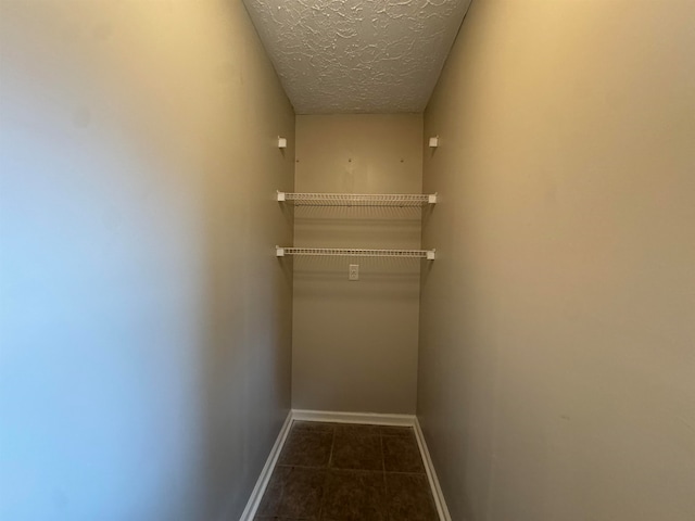 walk in closet with dark tile patterned floors