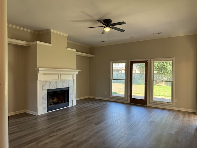 unfurnished living room featuring dark hardwood / wood-style floors, ceiling fan, crown molding, and a tile fireplace