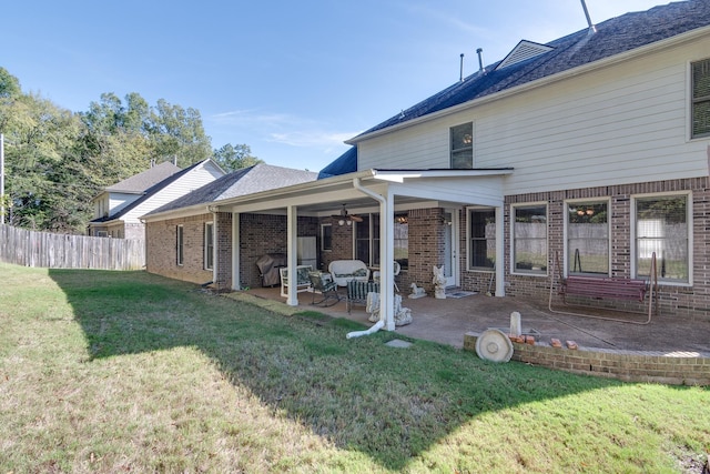 back of property featuring ceiling fan, a yard, and a patio