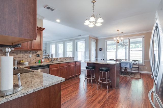 kitchen featuring crown molding, stainless steel appliances, dark hardwood / wood-style flooring, sink, and an inviting chandelier