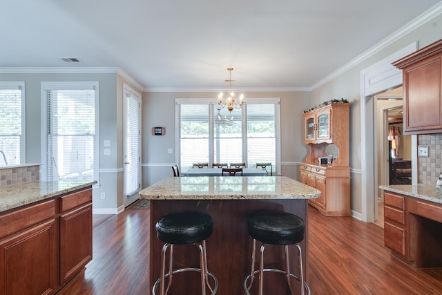 kitchen with plenty of natural light, backsplash, dark hardwood / wood-style flooring, and a center island