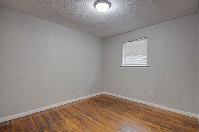 spare room with dark hardwood / wood-style flooring and a textured ceiling