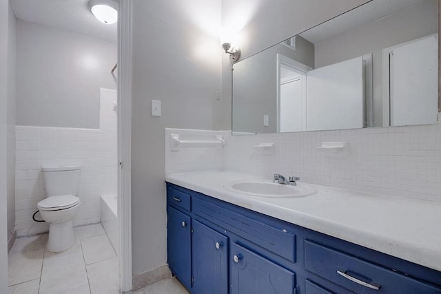 full bathroom with tile walls, vanity, tile patterned flooring, toilet, and washtub / shower combination