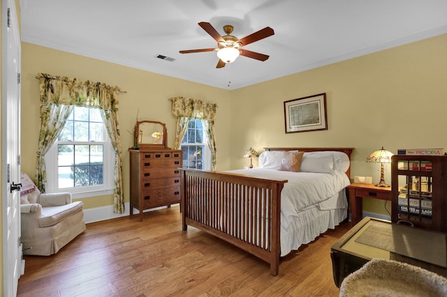 bedroom with crown molding, ceiling fan, and light wood-type flooring