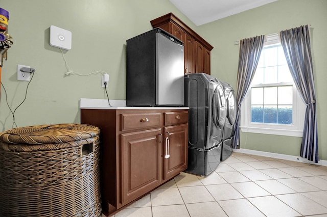 washroom featuring cabinets, light tile patterned floors, and independent washer and dryer