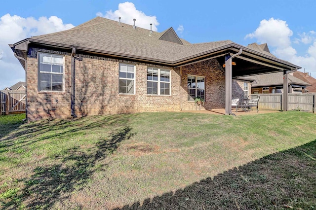 rear view of property featuring a lawn and a patio