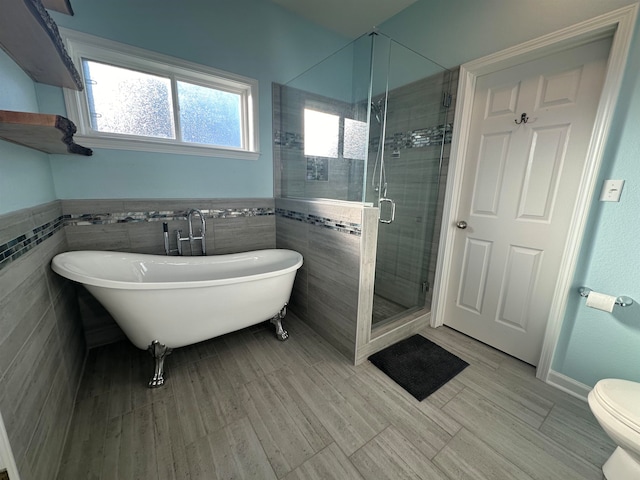 bathroom featuring tile walls, shower with separate bathtub, toilet, and wood-type flooring