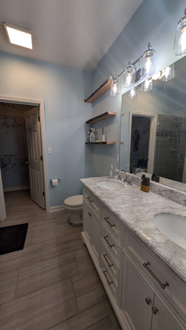 bathroom with an enclosed shower, vanity, hardwood / wood-style flooring, and toilet