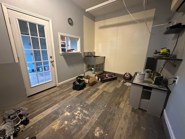 interior space with dark wood-type flooring, sink, and a wall mounted air conditioner