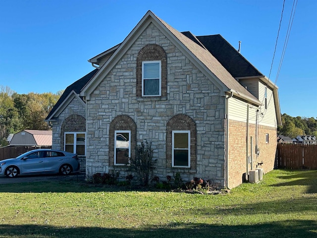 french country inspired facade with cooling unit and a front yard