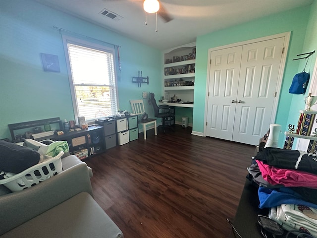 interior space with dark hardwood / wood-style flooring, built in desk, and ceiling fan