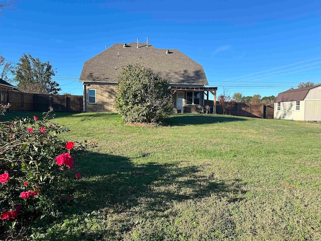 rear view of property with a storage unit and a lawn