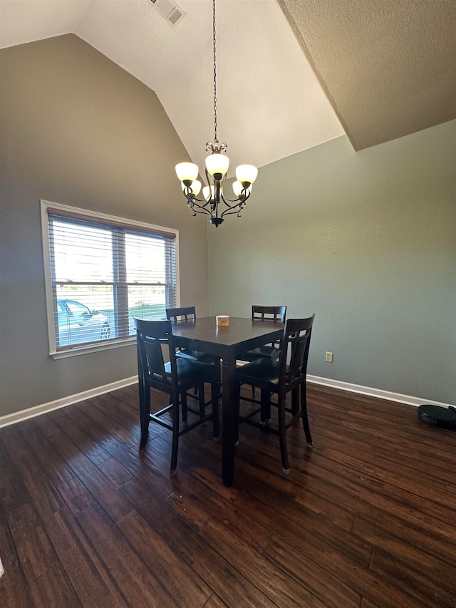 dining space with dark hardwood / wood-style flooring, an inviting chandelier, and vaulted ceiling