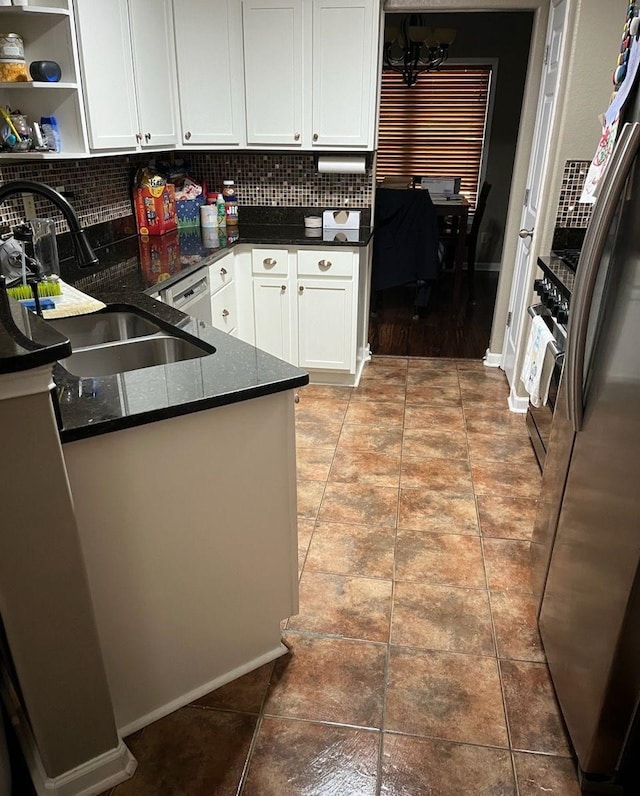 kitchen with white cabinetry, sink, kitchen peninsula, appliances with stainless steel finishes, and decorative backsplash