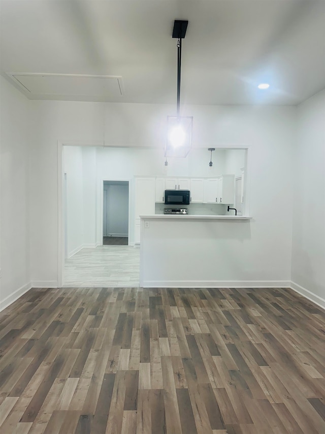 kitchen featuring dark hardwood / wood-style flooring, white cabinetry, and kitchen peninsula